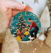 a person holding a christmas ornament in their hand