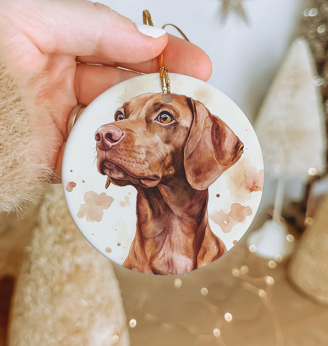 a hand holding a christmas ornament with a picture of a dog on it