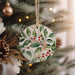 a ceramic ornament hanging from a christmas tree