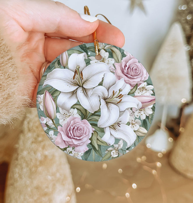 a person holding a christmas ornament with flowers on it