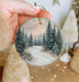 a person holding a christmas ornament in their hand