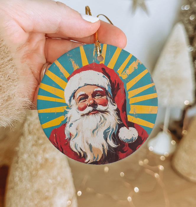 a hand holding a christmas ornament with a santa clause on it