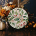 a ceramic ornament decorated with leaves and berries