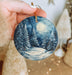 a person holding a christmas ornament in their hand