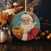 a christmas ornament with a santa clause holding a present