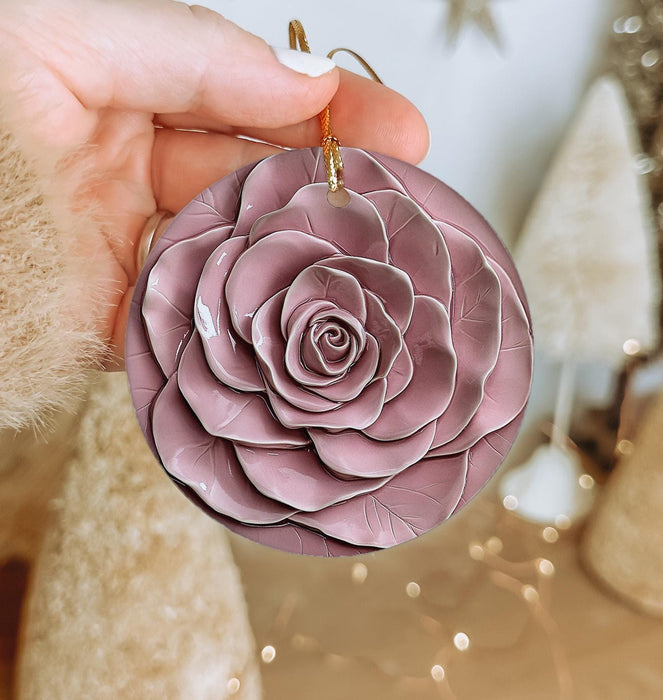 a person holding a pink flower ornament in their hand