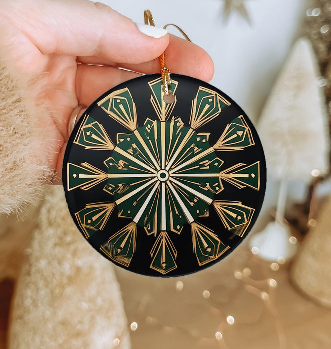 a hand holding a black and gold ornament