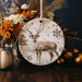 a ceramic ornament with a deer and snowflakes on it