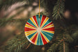 a colorful ornament hanging from a christmas tree
