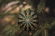 a black and gold ornament hanging from a tree