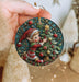 a person holding a christmas ornament in their hand