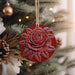 a red ornament hanging from a christmas tree
