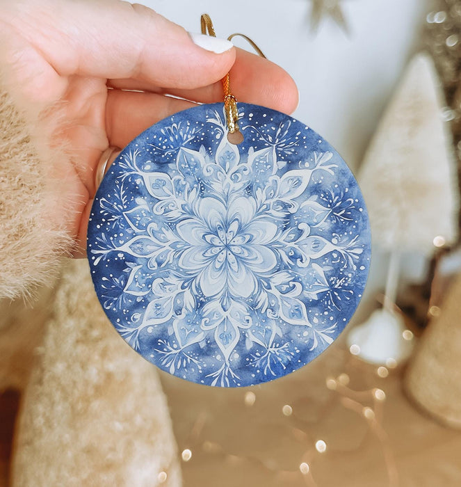 a hand holding a blue and white ornament