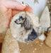 a hand holding a christmas ornament with a dog on it
