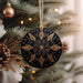 a black and gold ornament hanging from a christmas tree
