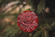 a red ornament hanging from a christmas tree