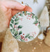 a person holding a christmas ornament in their hand