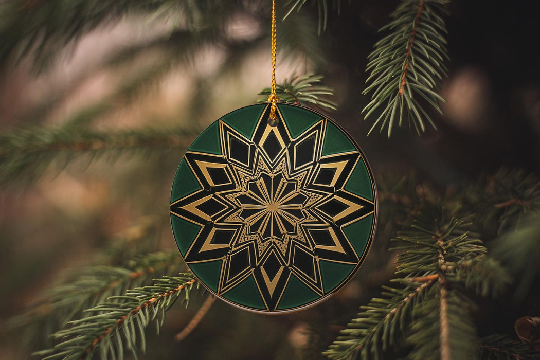a green and gold ornament hanging from a tree