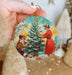 a person holding a christmas ornament in their hand