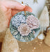 a person holding a flower ornament in their hand