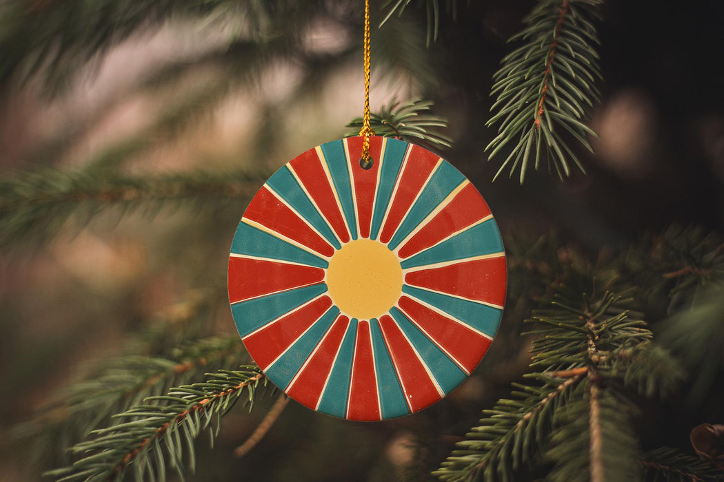 a red, blue, and yellow ornament hanging from a christmas tree