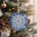 a blue and white ornament hanging from a christmas tree