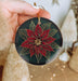 a person holding a christmas ornament in their hand