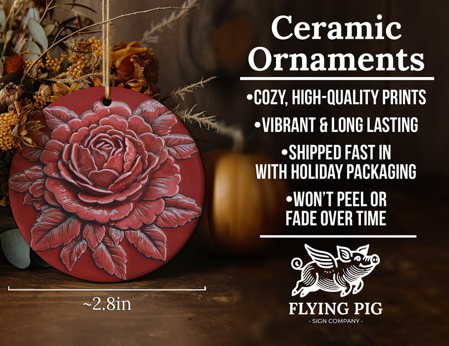 a red ceramic ornament with a rose on it