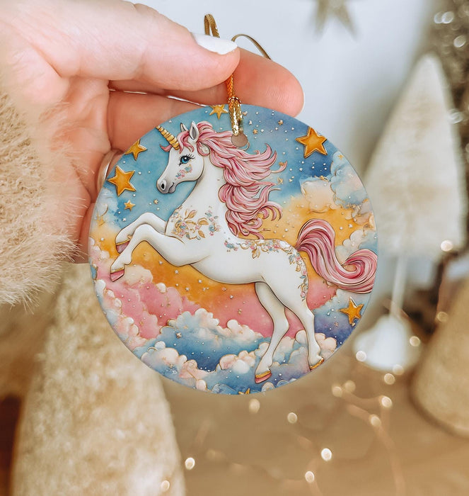 a hand holding a round ornament with a unicorn on it