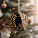 a black and gold ornament hanging from a christmas tree