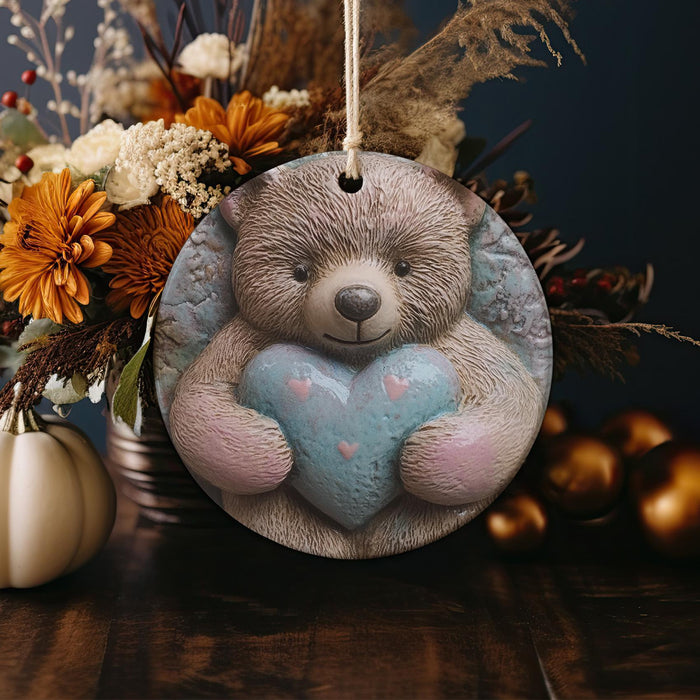 a ceramic ornament with a teddy bear holding a heart