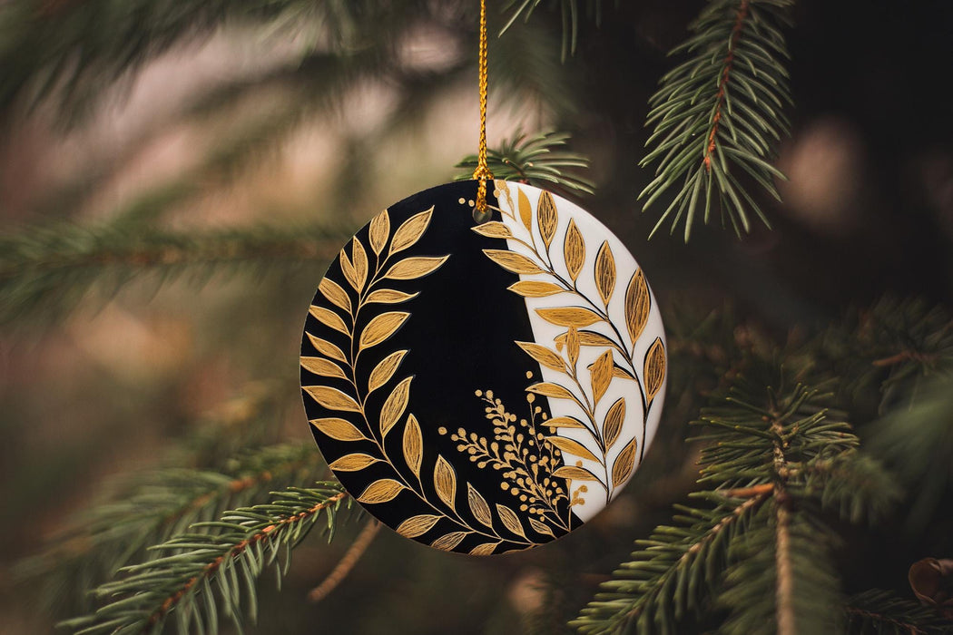 a black and gold ornament hanging from a christmas tree