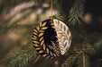 a black and gold ornament hanging from a christmas tree