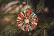 a red, white, and blue ornament hanging from a christmas tree