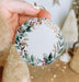 a person holding a christmas ornament in their hand