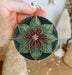 a person holding a christmas ornament in their hand