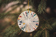 a christmas ornament hanging from a pine tree