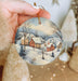 a person holding a christmas ornament in their hand