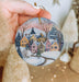 a person holding a christmas ornament in their hand