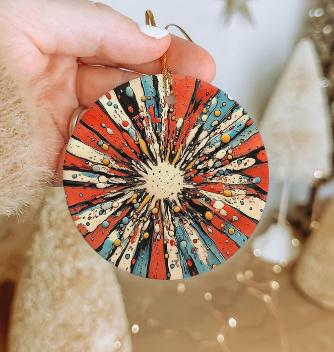 a hand holding a red, white, and blue ornament