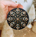 a person holding a christmas ornament in their hand