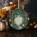 a ceramic ornament with a forest scene on it