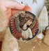 a person holding a christmas ornament in their hand
