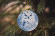 an ornament hanging from a tree with a picture of an owl on it
