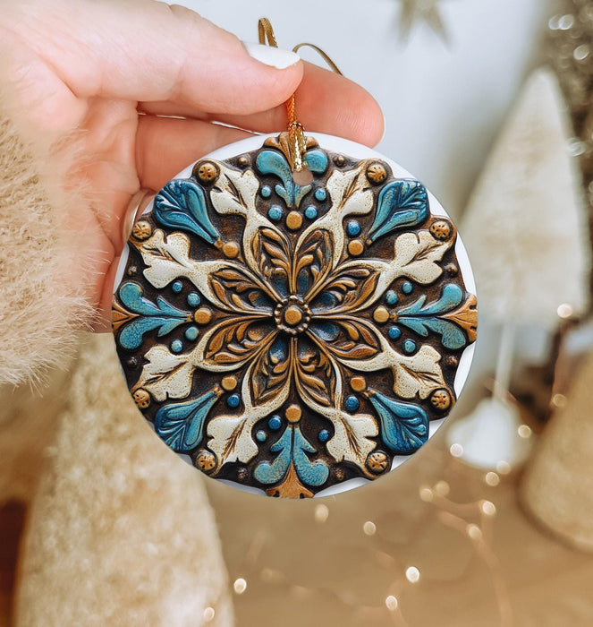 a hand holding a christmas ornament in front of a christmas tree