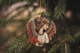 a ceramic angel ornament hanging from a pine tree