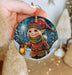 a person holding a christmas ornament in their hand