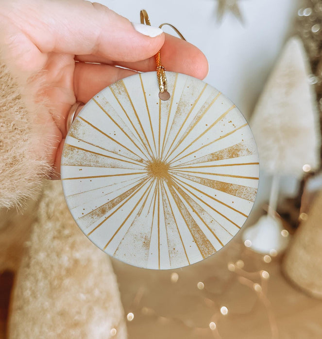 a person holding a white and gold ornament