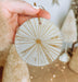 a person holding a white and gold ornament