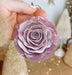 a person holding a purple flower ornament in their hand